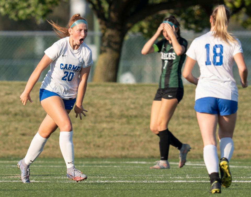 Carmel’s Megan Hamm (20) and Zionsville’s Karley Johnson (7) both react to Hamm’s goal Thursday, Oct. 6, 2022, at Westfield High School. 