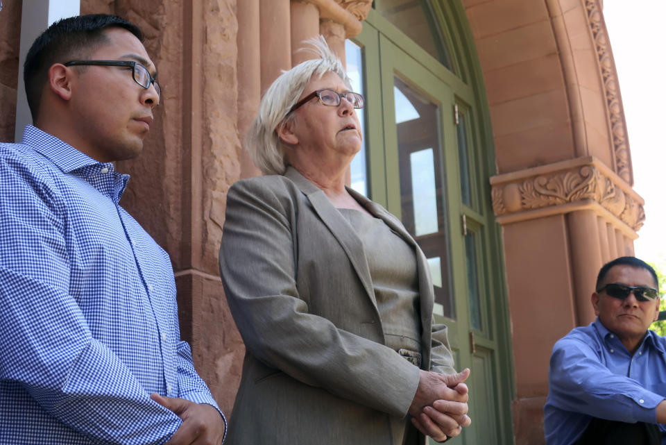 FILE - In this June 28, 2019, file photo, Wendy White, right, speaks at a news conference outside the Coconino County courthouse in Flagstaff, Ariz., as Tremayne Nez, left, looks on. In June 2019, police wrongfully arrested him on suspicion of selling LSD after they mistook Nez, who is Navajo, for the actual suspect, also Native American. After spending more than 30 hours in jail in 2019, he posted bond but his mug shot had already been released, tarnishing his reputation throughout the tribal community. Booking photos taken by police when a person is arrested are often made public, but some experts say releasing someone's mug shot can undermine the presumption of innocence, perpetuate stereotypes and leave a lasting virtual stain.. (AP Photo/Felicia Fonseca, File)