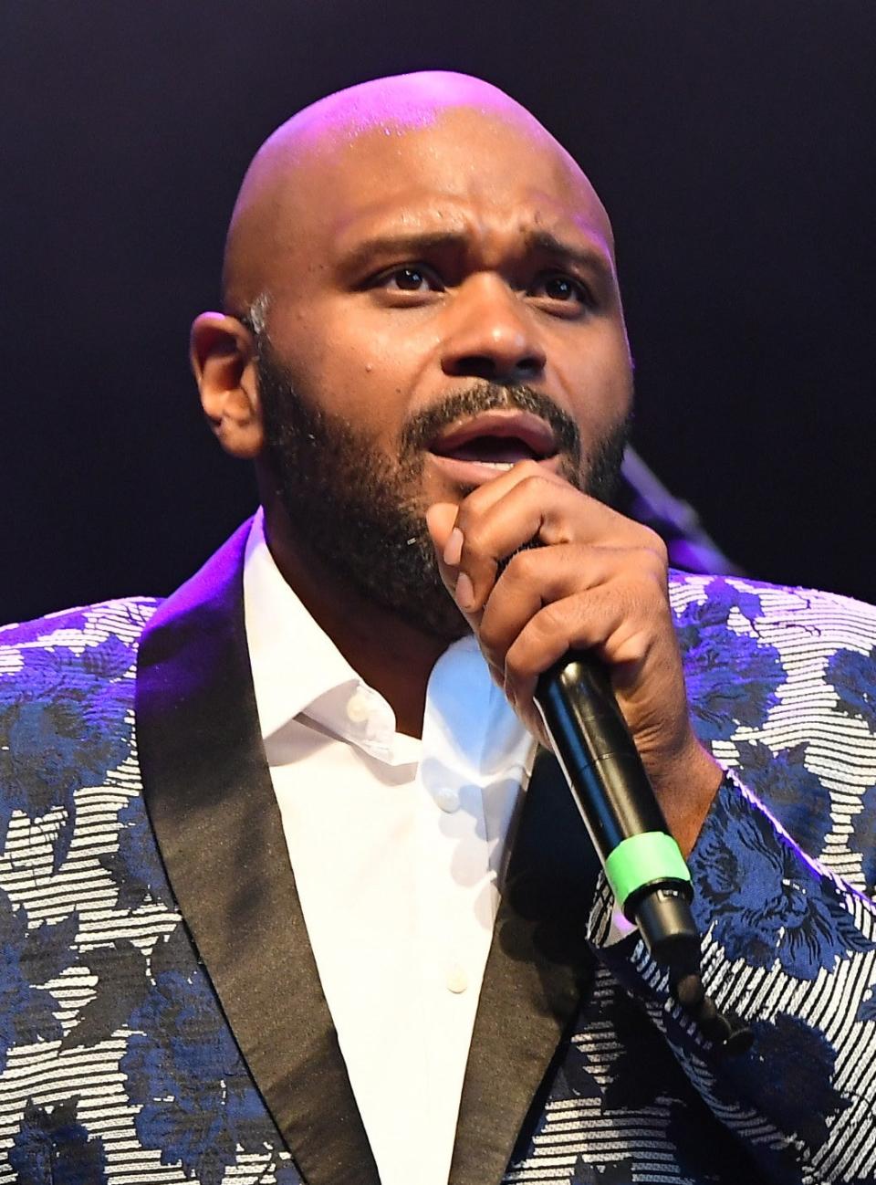 close up of Ruben singing in a floral suit