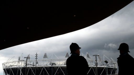 Metropolitan police officers look toward the Olympic Stadium from the entrance to the swimming venue in April 2012. British authorities insisted Thursday that Olympic security would not be compromised after having to draft in an extra 3,500 troops because a private security firm failed to provide enough guards