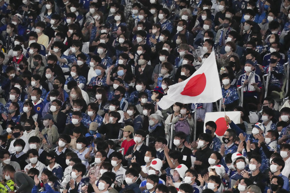 Japan's soccer fans wearing face mask watch a friendly match between Brazil and Japan team at the National Stadium in Tokyo Monday, June 6, 2022. (AP Photo/Eugene Hoshiko)