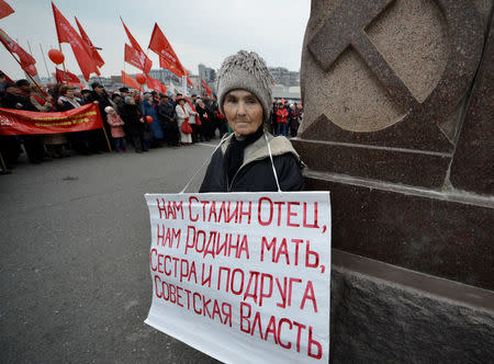 A woman holds a placard as she takes part in a rally to mark the Red October revolution's centenary in the far eastern city of Vladivostok, Russia November 7, 2017. The placard reads, "Stalin is our father, homeland is our mother, Soviet power is our sister and our friend". REUTERS/Yuri Maltsev