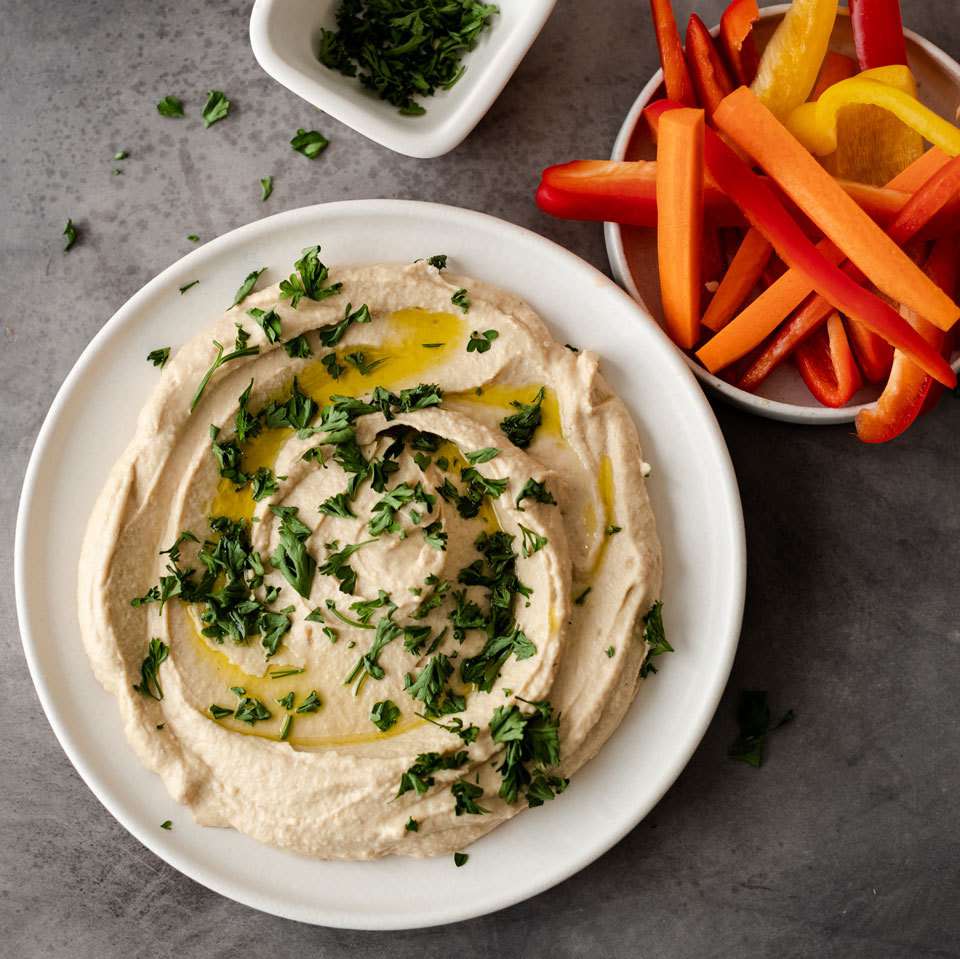 hummus in bowl with herbs