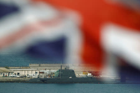 The Union Jack is seen flying while a British nuclear Astute-class submarine HMS Ambush is seen docked in a port while it is repaired after it was involved in a "glancing collision" with a merchant vessel off the coast of the peninsula of Gibraltar on Wednesday, in the British overseas territory of Gibraltar, July 21, 2016. REUTERS/Jon Nazca