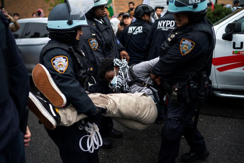 New York Police Department officers arrest a demonstrator during the protest in Brooklyn on 18 May (REUTERS)