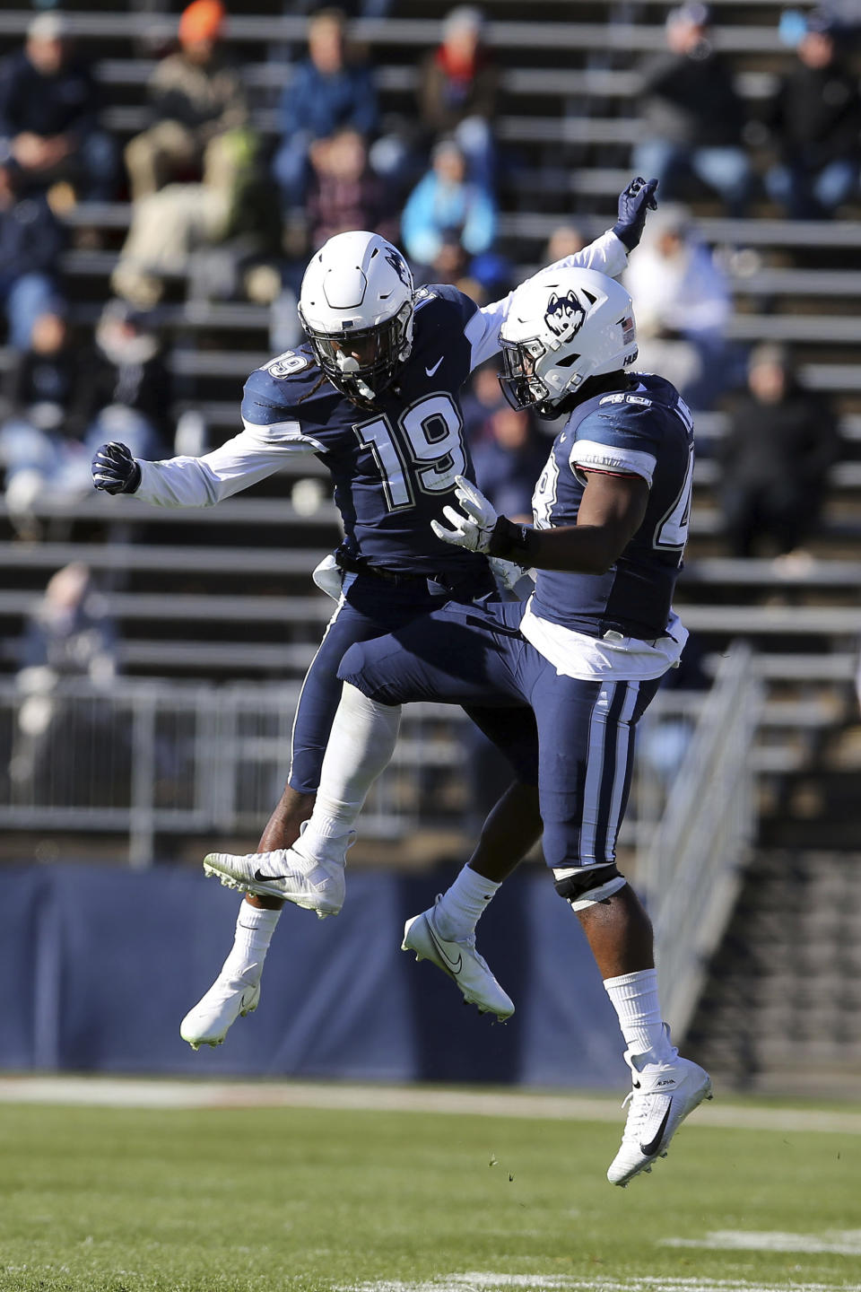 Connecticut defensive back Durante Jones (19) and defensive lineman Kevon Jones (48) celebrate a defensive stop during the first half of an NCAA football game against Houston, Saturday, Nov. 27, 2021, in East Hartford, Conn. (AP Photo/Stew Milne)