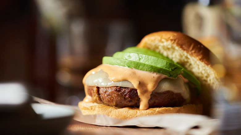 burger with sauce and avocado