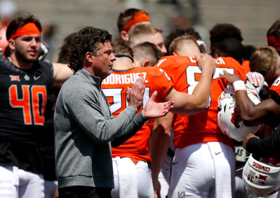 Mike Gundy claps as the team gathers on the field of Boone Pickens Stadium following the Cowboys' spring game in April 2022. That was the last time OSU held a spring game.