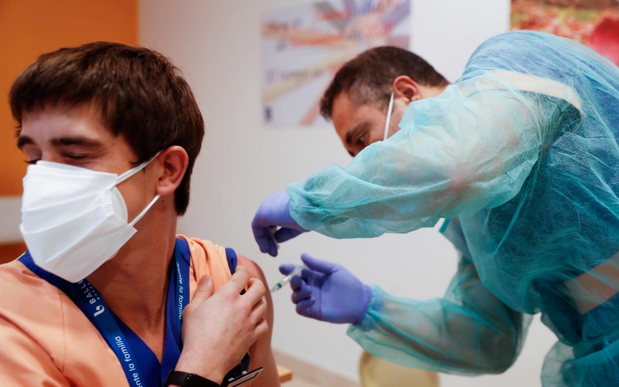 A young Spanish man receiving a vaccine - Susana Vera/Reuters