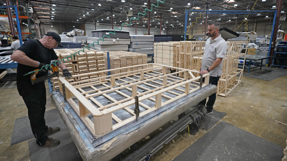 Mattress maker Schuyler Northstrom, right, of Uinta Mattress, looks on during production in his warehouse Friday, Sept. 9, 2022, in Salt Lake City. Inflation and rising costs for everything from labor to raw materials have forced many small businesses to raise prices. Mattress maker Schuyler Northstrom saw a drop in customer demand after raising prices. (AP Photo/Rick Bowmer)