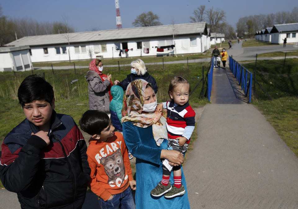Migrants wait in garden during the vaccination in the "Krnjaca" refugee centre near Belgrade, Serbia, Friday, March 26, 2021. Serbia has started vaccinating migrants as the Balkan country struggles with a new coronavirus outbreak despite a widespread inoculation campaign. (AP Photo/Darko Vojinovic)