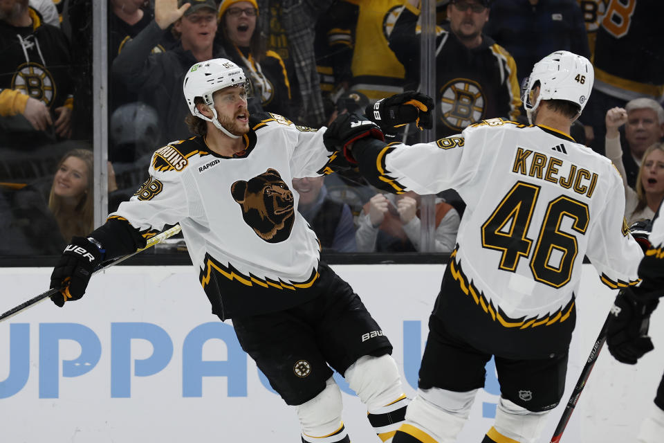 Boston Bruins' David Pastrnak celebrates his second goal of the game with teammate David Krejci during the second period of an NHL hockey game against the Colorado Avalanche Saturday, Dec. 3, 2022, in Boston. (AP Photo/Winslow Townson)