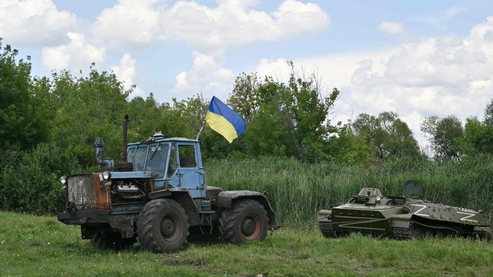 A farm tractor tows an armoured personnel carrier, abandoned by Russian troops and commandeered by a Ukrainian farmer. (AFP via Getty Images)