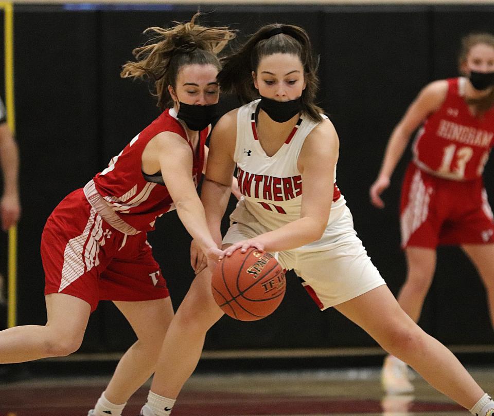 Whitman-Hanson's Caitlin Leahy protects the ball against Hingham's Colette Haney during a game at Whitman-Hanson Regional High School on Friday, Jan. 21, 2022.