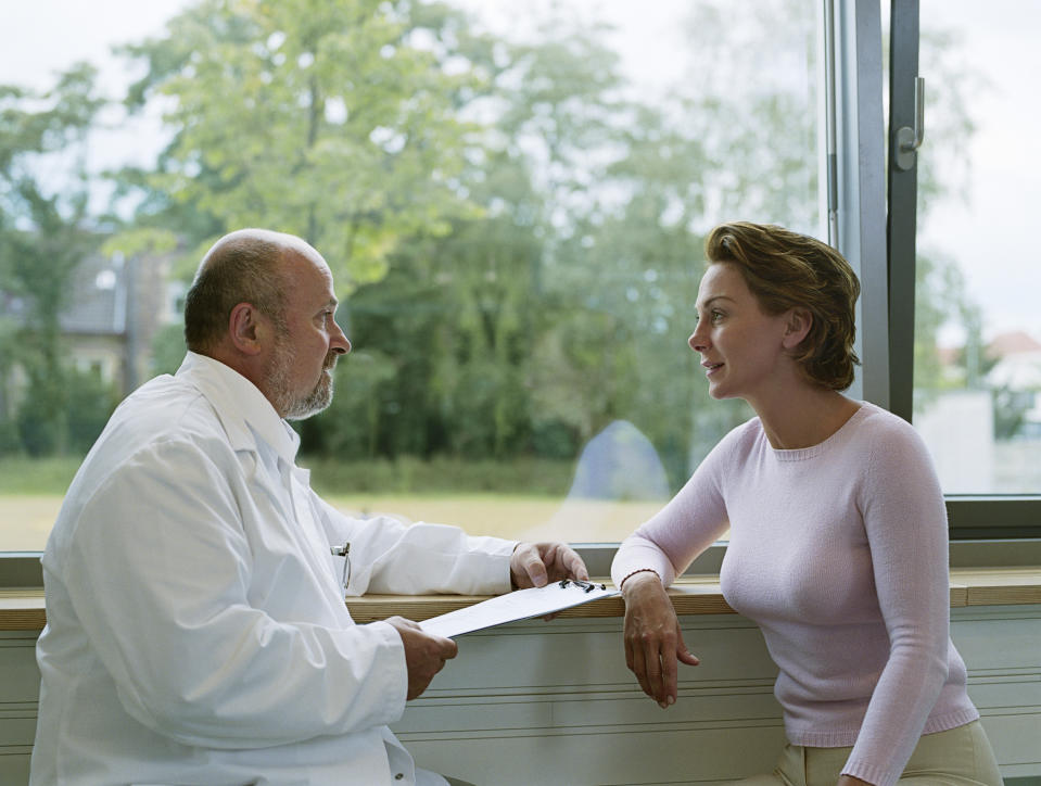 Woman talking to a doctor in front of a window