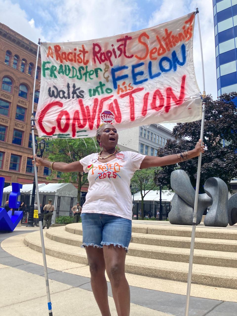 Nadine Seiler holds a sign outside the security entrance near the Baird Center on Tuesday, July 16, 2024.