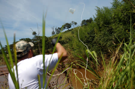 A member of SOS Mata Atlantica Foundation collects samples as they start an expedition on the Paraopeba River to understand the environmental impact of the mudslide after a tailings dam owned by Brazilian mining company Vale SA collapsed, in Brumadinho, Brazil January 31, 2019. REUTERS/Adriano Machado