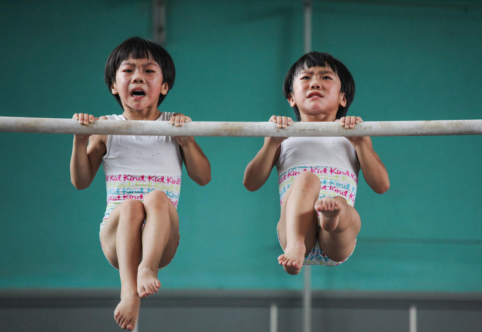 <p>Two little twins struggle during gymnastics training in China. Photographer Yuan Peng won the sport category (Yuan Peng) </p>