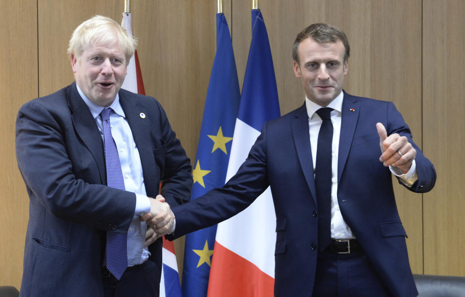 Britain's Prime Minister Boris Johnson poses with French President Emmanuel Macron, right, during a European Union leaders summit in Brussels, Belgium, Thursday Oct. 17, 2019. Britain and the European Union reached a new tentative Brexit deal on Thursday, hoping to finally escape the acrimony, divisions and frustration of their three-year negotiation. (Johanna Geron/Pool via AP)