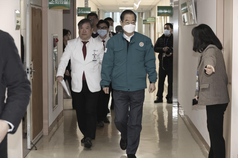 South Korean Prime Minister Han Duck-soo, center, arrives for a meeting with doctors at National Police Hospital in Seoul, South Korea, Wednesday, Feb. 21, 2024. South Korea on Wednesday officially ordered thousands of striking doctors to return to work immediately, a step that could lead to legal punishments if the doctors don't end their walkouts, which have caused numerous cancellations of surgeries and other treatments at hospitals. (Hwang Gang-mo/Yonhap via AP)