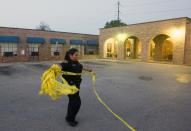 A police officer cleans up crime scene tape as they investigate the scene of a homicide at Lexington Nursing & Rehabilitation Wednesday, April 23, 2014, in Houston. Guillermo Correa, 56, is accused of using the armrest of his wheelchair to beat two of his roommates to death a the nursing home is facing a capital murder charge, police said Wednesday. Correa was in custody after being formally charged following the Tuesday evening incident. (AP Photo/Houston Chronicle, Cody Duty) MANDATORY CREDIT