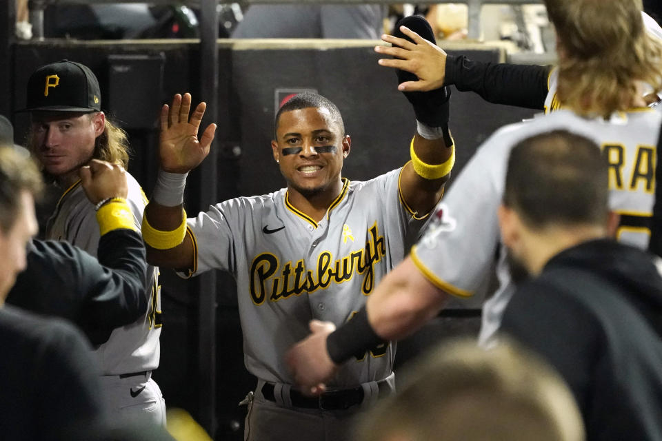 Pittsburgh Pirates' Wilmer Difo is greeted in the dugout after scoring on a single by Cole Tucker during the fifth inning of a baseball game against the Chicago White Sox Wednesday, Sept. 1, 2021, in Chicago. (AP Photo/Charles Rex Arbogast)