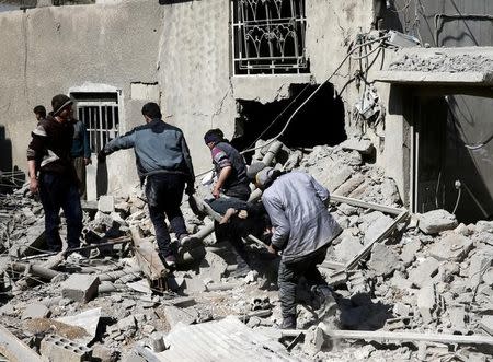 People carry the body of Majid Santiha on a stretcher in the besieged eastern Ghouta town of Hamouriyeh near Damascus, Syria, February 21, 2018. REUTERS/Bassam Khabieh/File Photo