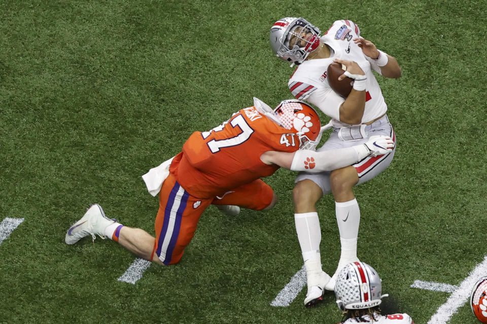 Ohio State quarterback Justin Fields gets hit by Clemson linebacker James Skalski during the first half of the Sugar Bowl NCAA college football game Friday, Jan. 1, 2021, in New Orleans. Skalski was ejected from the game for targeting.(AP Photo/Butch Dill)