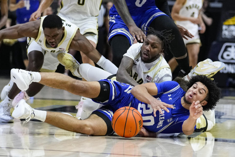 Purdue guard David Jenkins Jr., top right, and guard Brandon Newman (5) go for a loose ball with New Orleans guard Khaleb Wilson-Rouse (20) during the second half of an NCAA college basketball game in West Lafayette, Ind., Wednesday, Dec. 21, 2022. (AP Photo/Michael Conroy)