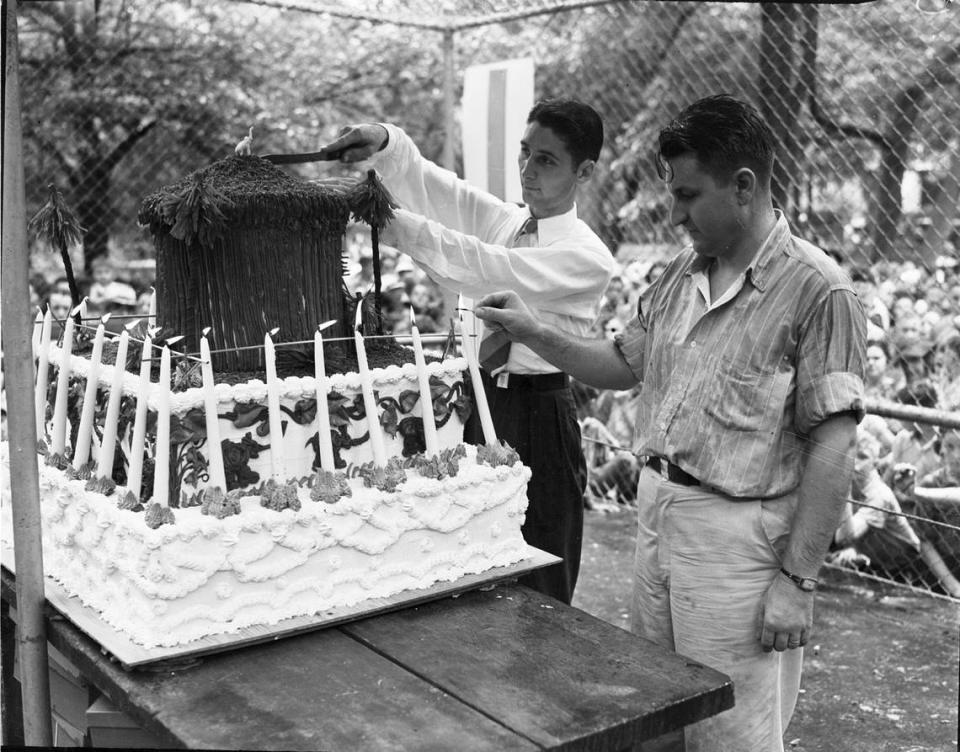 Aug. 12, 1938: Birthday cake for Queen Tut, Forest Park Zoo’s 18-year-old elephant; lighting candles is zookeeper Hamilton Hittson, and Byron Buckeridge, the zoo’s educational director, cuts the cake.