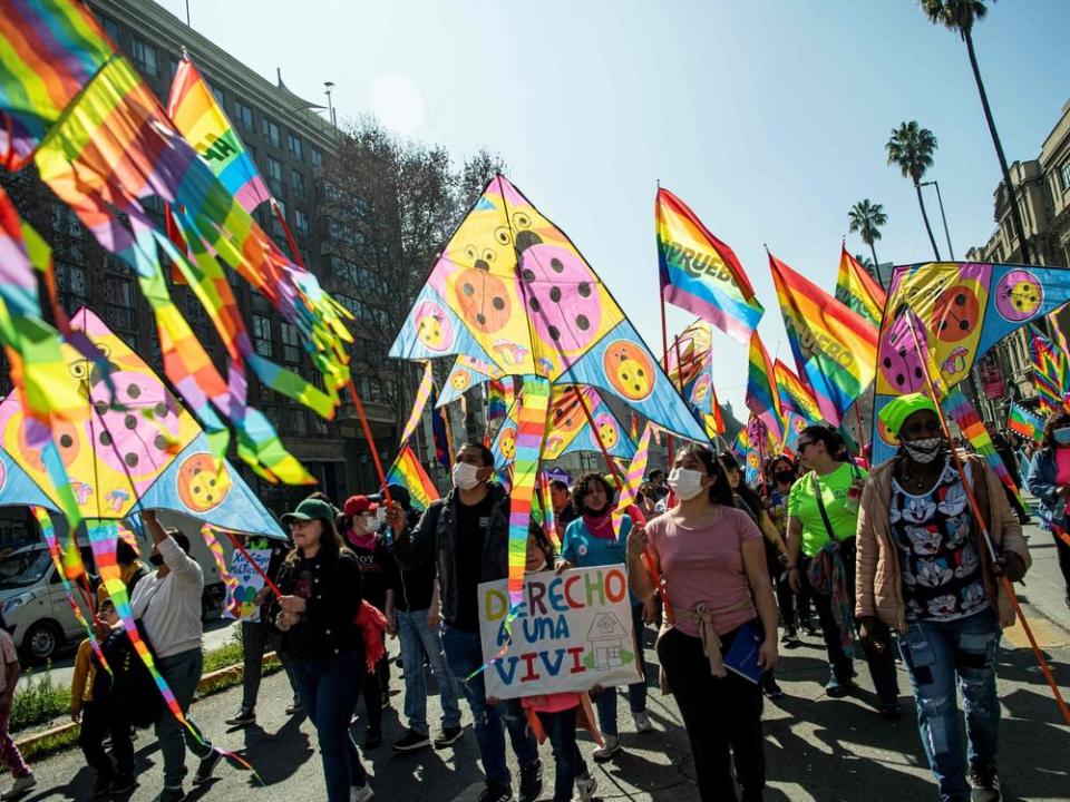  People hold flags during a march in support of the new constitution on August 20, 2022 in Santiago.