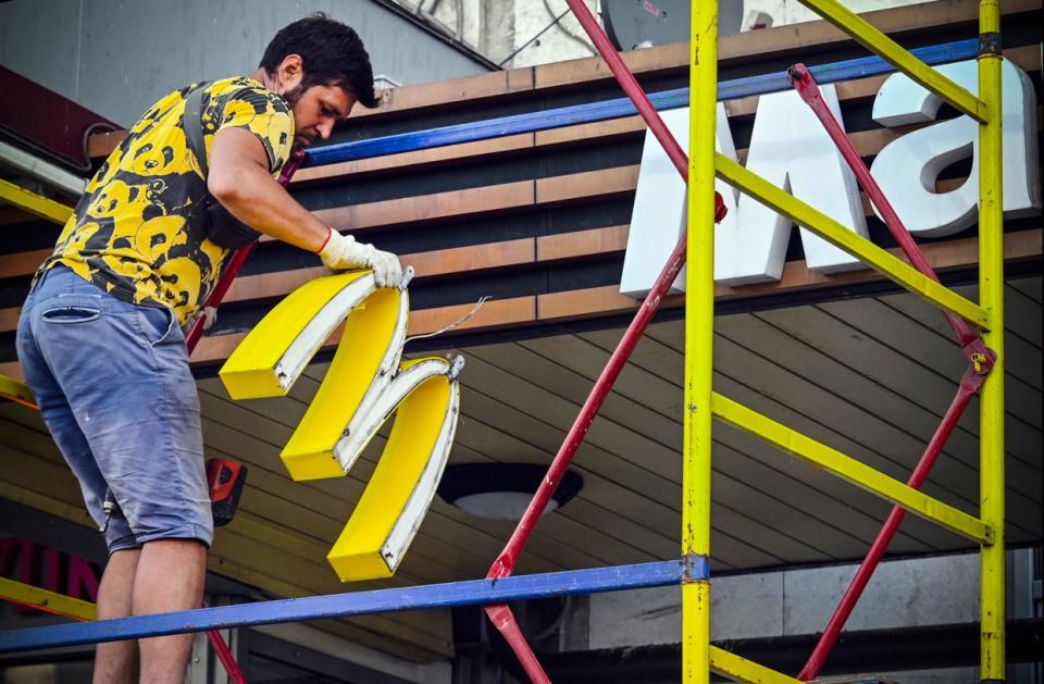 A worker removes the McDonald's logotype from a restaurant in Moscow on June 17, 2022. McDonald's sold its Russian business to Russian businessman Alexander Govor, a licensee of the chain. Former McDonald's restaurants in Russia have been renamed "Vkusno i tochka" (Tasty and That's it!). (Alexander Nemenov /AFP via Getty Images)