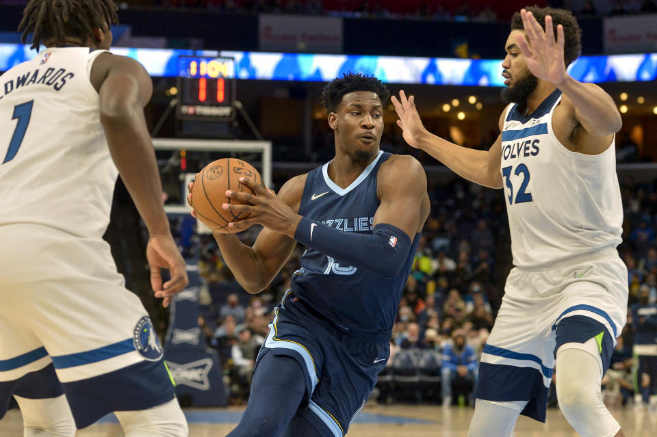 Memphis Grizzlies forward Jaren Jackson Jr. (13) drives against Minnesota Timberwolves center Karl-Anthony Towns (32) in the first half of an NBA basketball game Thursday, Jan. 13, 2022, in Memphis, Tenn. (AP Photo/Brandon Dill)