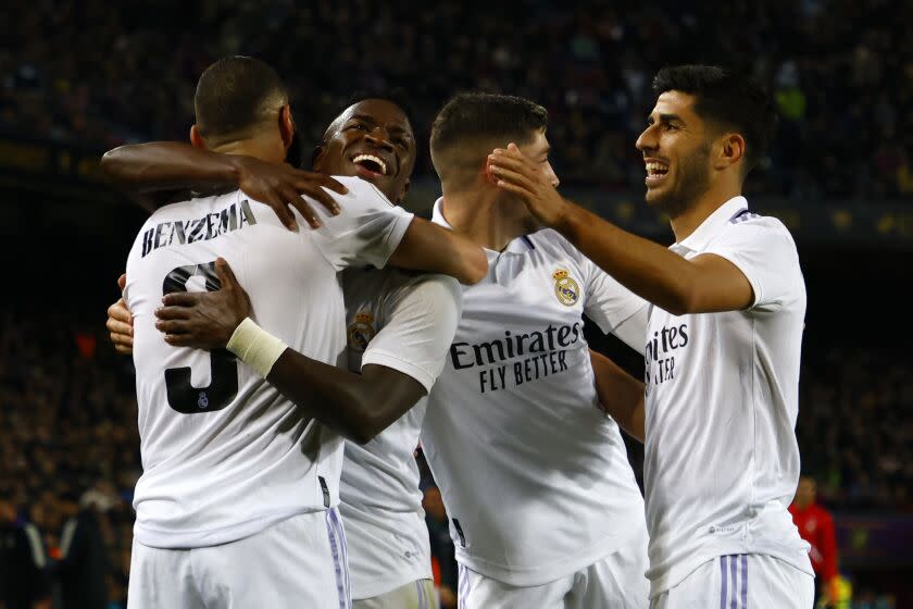 Real Madrid's Karim Benzema, left, celebrates with his teammates after scoring his side's fourth goal during the Spanish Copa del Rey semifinal, second leg soccer match between Barcelona and Real Madrid at the Camp Nou stadium in Barcelona, Spain, Wednesday, April 5, 2023. (AP Photo/Joan Monfort)