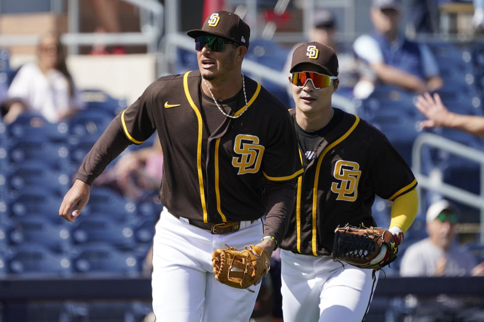 San Diego Padres' Manny Machado, left, runs off the field after tagging out Cleveland Indians' Bobby Bradley in the third inning a spring training baseball game Thursday, March 11, 2021, in Peoria, Ariz. (AP Photo/Sue Ogrocki)
