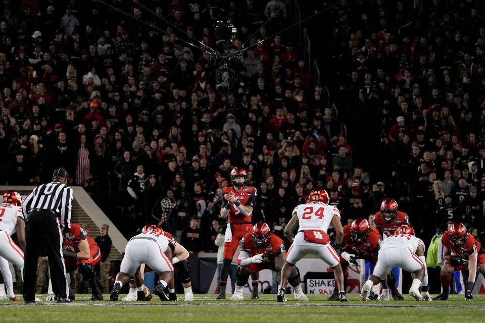 FILE - Cincinnati quarterback Desmond Ridder prepares to take the snap during the second half of an American Athletic Conference championship NCAA college football game against Houston on Dec. 4, 2021, in Cincinnati. The American Athletic Conference announced an agreement, Friday, June 10, 2022, with Cincinnati, Houston and UCF that paves the way for the schools to join the Big 12 in 2023. (AP Photo/Jeff Dean, File)