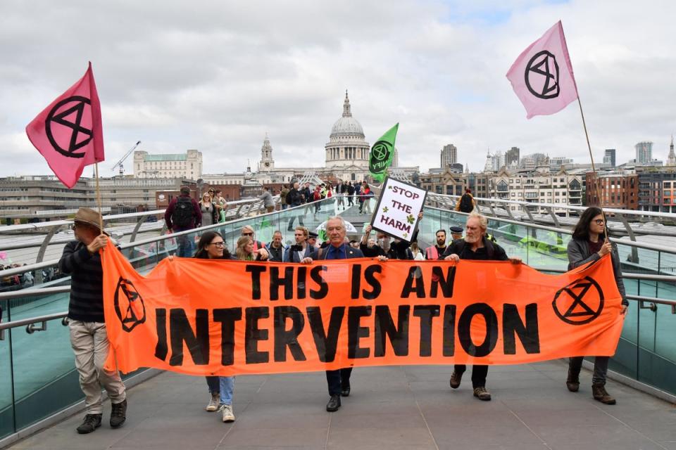 Climate activists from the Extinction Rebellion group cross the Millennium bridge in central London (AFP via Getty Images)