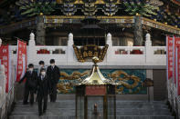 In this Feb. 13, 2020, photo, a group of people in school uniforms walk down the steps of a temple in Yokohama's Chinatown, near Tokyo. A top Olympic official made clear Friday the 2020 Games in Tokyo will not be cancelled despite the virus that has spread from China. (AP Photo/Jae C. Hong)