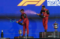 First placed Ferrari driver Charles Leclerc of Monaco, right, and second placed Ferrari driver Carlos Sainz of Spain celebrate on the podium after the Formula One Bahrain Grand Prix it in Sakhir, Bahrain, Sunday, March 20, 2022. (AP Photo/Hassan Ammar)