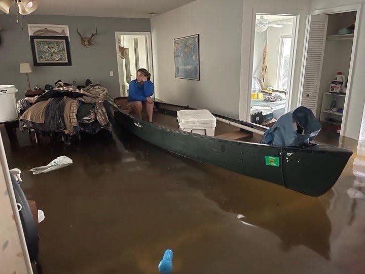 Hannah Herrero of Green Road in New Smyrna Beach sits on her canoe as flooding from Tropical Storm Ian made her home unlivable.