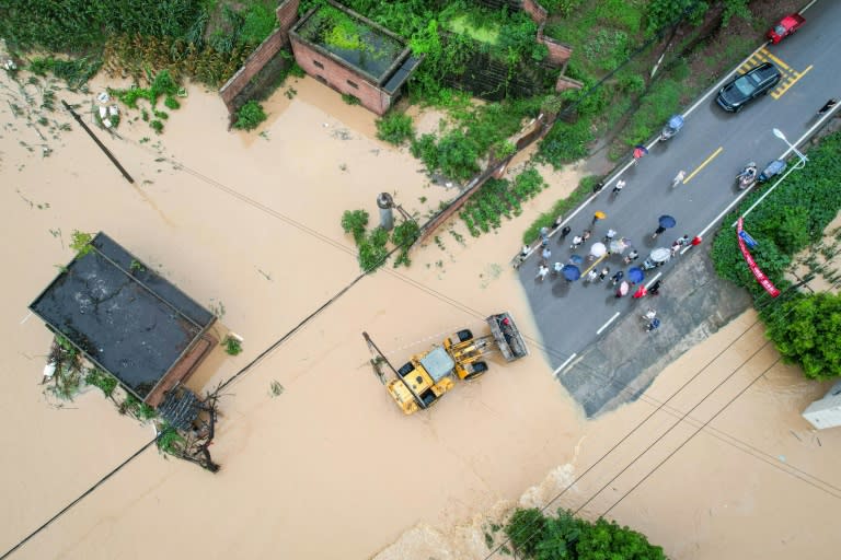 Vista aérea de unas personas siendo evacuadas por una excavadora en una zona inundada a causa de las fuertes lluvias el 11 de julio de 2024 en Dianjiang, al suroeste de China (.)