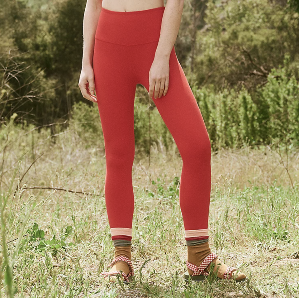 model wearing socks and sandals and red leggings outside, The Great.  + Eddie Bauer The Hiking Leggings (Photo via The Great)