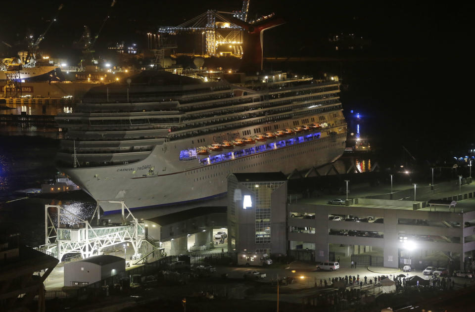 The cruise ship Carnival Triumph is pushed towards the cruise terminal along the Mobile River in Mobile, Ala., Thursday, Feb. 14, 2013. The ship with more than 4,200 passengers and crew members was idled for nearly a week in the Gulf of Mexico following an engine room fire. (AP Photo/Dave Martin)