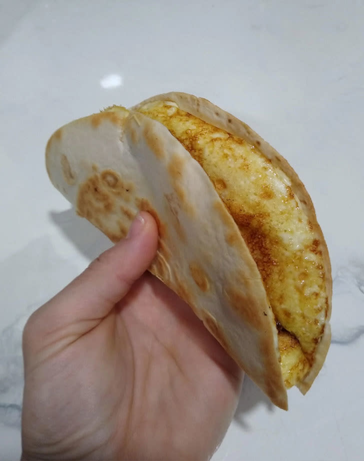 A hand holding an egg quesadilla