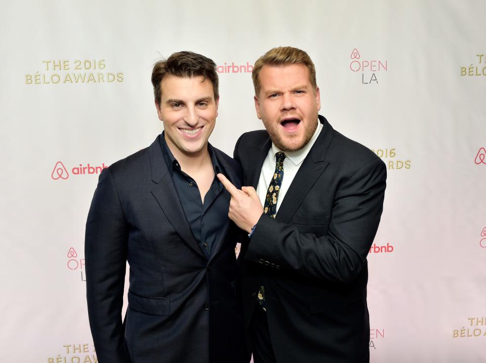 James Corden points to Brian Chesky with an enthusiastic expression on a red carpet