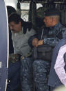 Joaquin "El Chapo" Guzmán (izquierda, con camisa blanca) sentado dentro de un helicóptero de la Policía Federal en un hangar de la Marina en la Ciudad de México el sábado 22 de febrero de 2014. Un alto funcionario estadounidense dijo el sábado que Guzmán, jefe del Cártel de Sinaloa, fue capturado en la ciudad turística de Mazatlán. Guzmán enfrenta varios encausamientos federales por drogas en Estados Unidos y está en lista de los más buscados de la DEA. (Foto AP/Eduardo Verdugo)