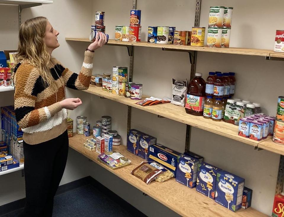 Corrin Toscano, a 22-year-old Gannon University graduate student, checks the expiration date on a can of beans in the Erie school's food pantry, Store U-Knighted. Toscano helps tend to the Store U-Knighted as part of her work-study job. Photo taken Nov. 30, 2022.