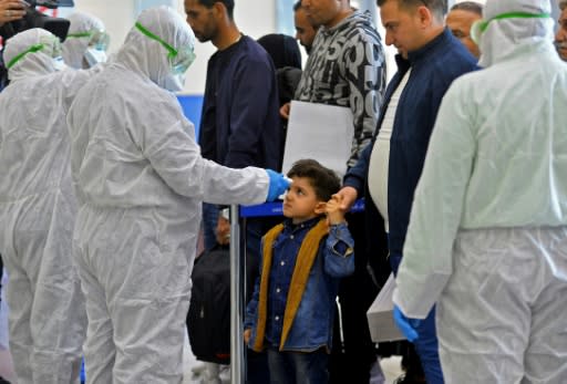 An Iraqi child's temperature is taken upon return from Iran at the Najaf International Airport on February 21