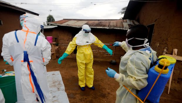 Healthcare worker Kavota Mugisha Robert decontaminates his colleague after he entered the house of 85-year-old woman suspected of dying of Ebola in the eastern Congolese town of Beni