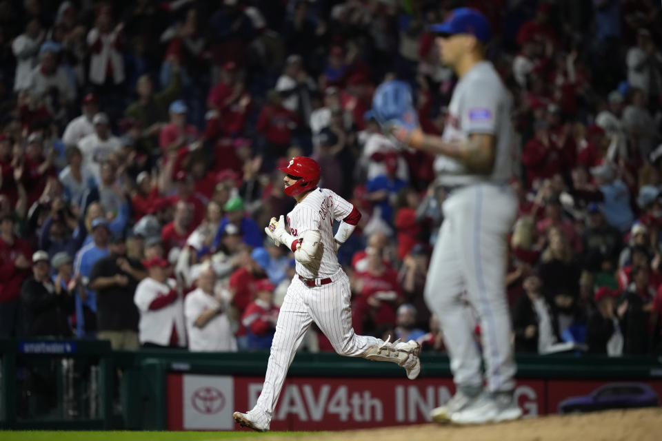 Philadelphia Phillies' Nick Castellanos, left, rounds the bases after hitting a two-run home run against New York Mets pitcher Jose Butto during the fourth inning of a baseball game, Sunday, Sept. 24, 2023, in Philadelphia. (AP Photo/Matt Slocum)